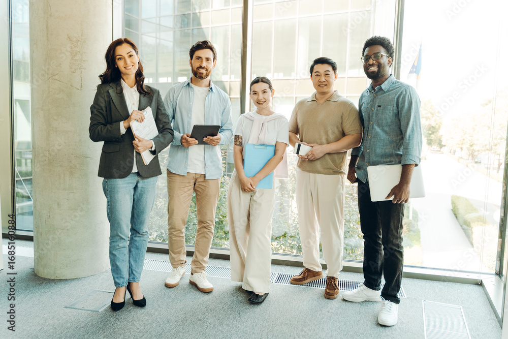 Fototapeta premium Diverse group of smiling business team smiling together in modern office