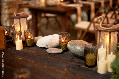 Handmade wooden lanterns and large stones in the d cor of the wedding table in the style of Vikings and warriors. Tree.