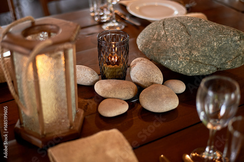 Handmade wooden lanterns and large stones in the d cor of the wedding table in the style of Vikings and warriors. Tree.