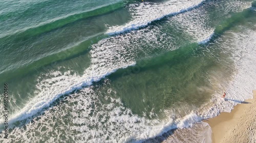 Woman walking on Golden beach near sea at Thassos Island, Greece. Amazing beach with clear blue water. Aerial panoramic drone view from above, top view from drone. Summer holidays Europe
