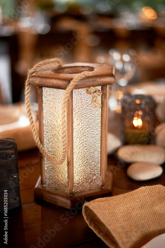 Handmade wooden lanterns and large stones in the d cor of the wedding table in the style of Vikings and warriors. Tree.