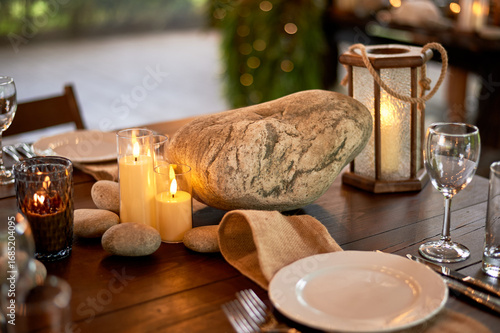 Handmade wooden lanterns and large stones in the d cor of the wedding table in the style of Vikings and warriors. Tree.