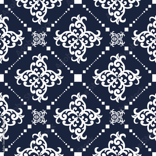 Elegant seamless pattern of intricate floral motifs in white on a dark background