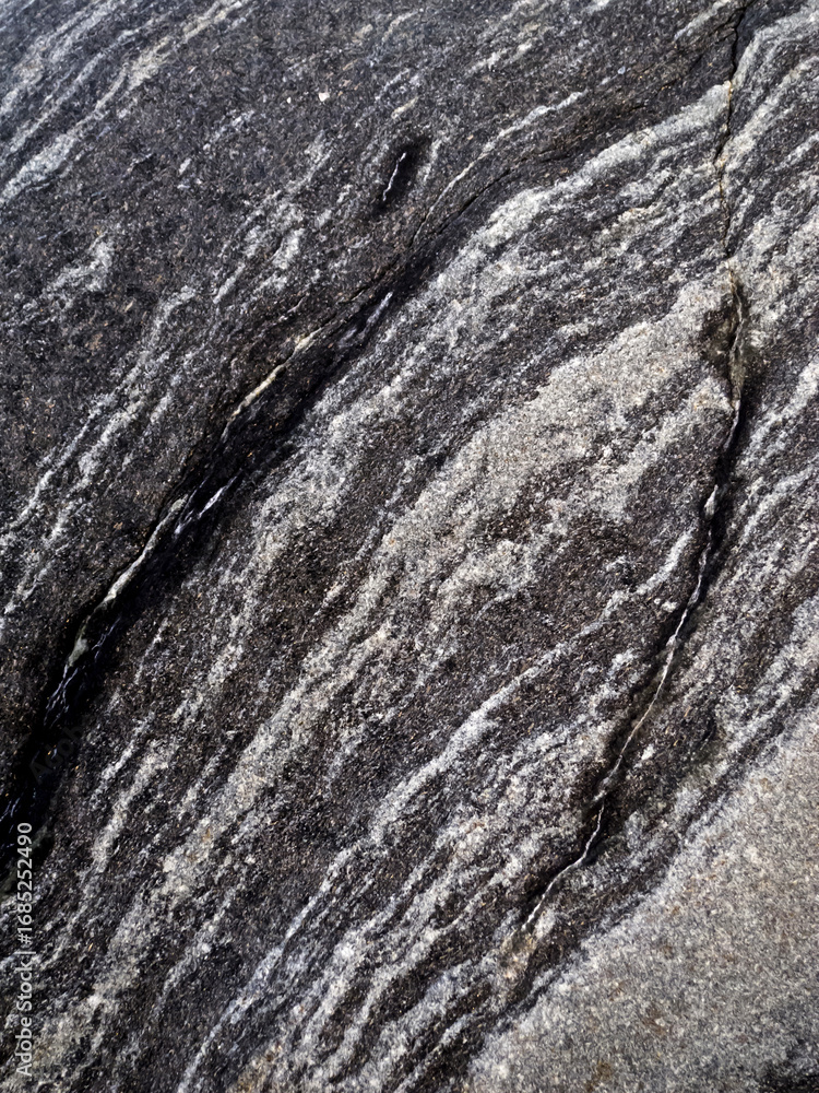 Naklejka premium Close-up of a rock surface with a pattern of dark and light bands.