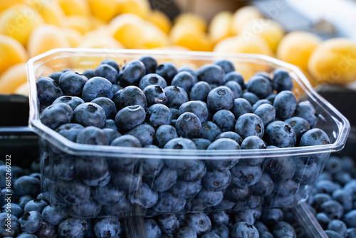 Wallpaper Mural Close-up of blueberries in market containers against fresh apricots background, organic seasonal fruits displayed for sale, detail of colorful summer harvest, natural healthy food,side view Torontodigital.ca