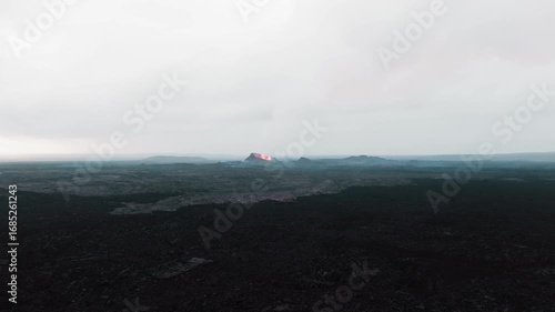 Aerial drone close up over the old dried up lava field and new eruptive crater of Sundhnukkar volcano