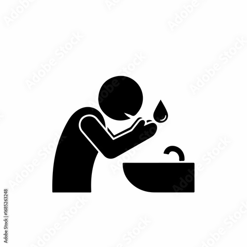 Black pictogram of a person washing their face at a sink.