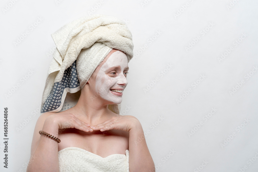 Obraz premium Woman in profile with her hands on her chest, a towel on her head and a facial mask. Lifestyle