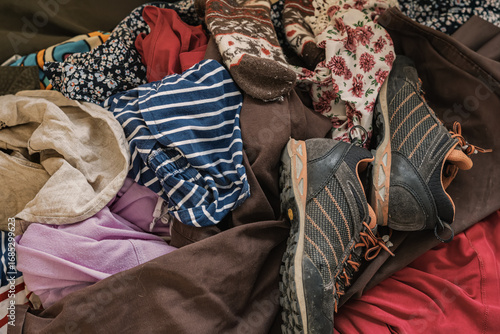 фотографія Mixed pile of worn clothes and used shoes symbolizing textile waste and recycling challenges