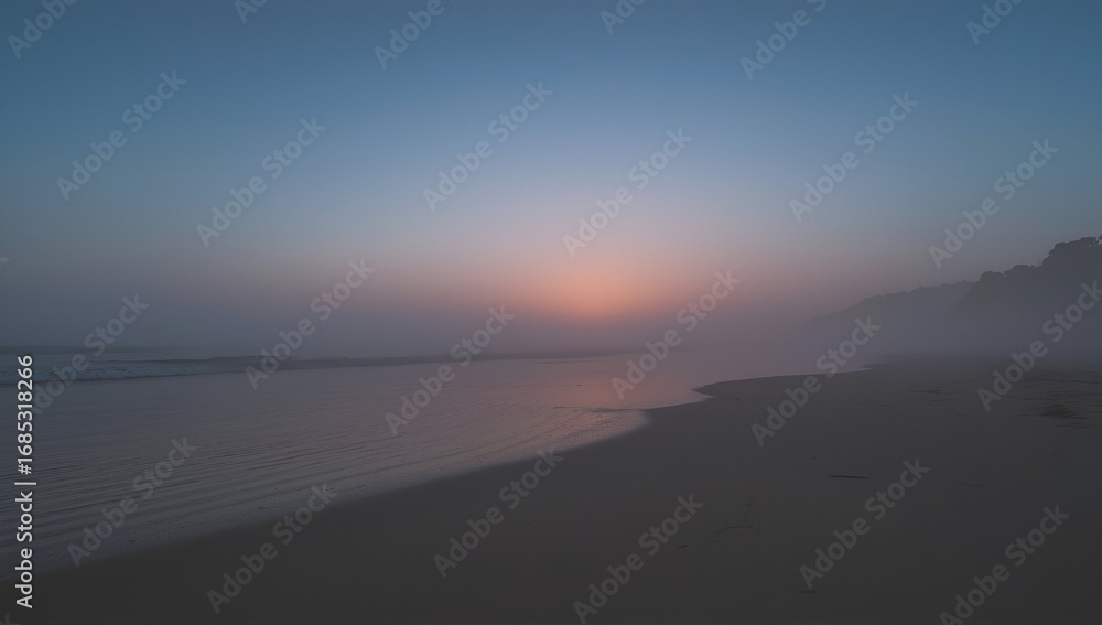 Obraz premium Misty Beach Sunrise with Fog Rolling Onto the Shoreline View