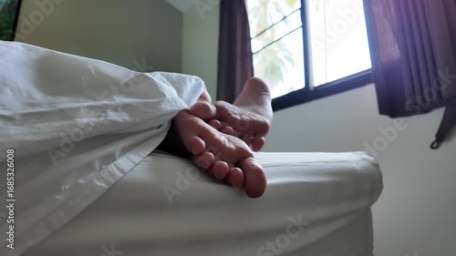 teenager's legs on hotel bed	