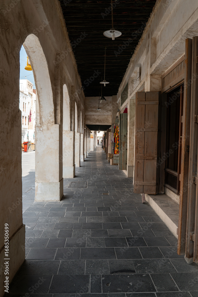 Obraz premium Traditional Qatari market with shops and storefronts, completely empty and without people. Historic Middle Eastern architecture and peaceful urban atmosphere.