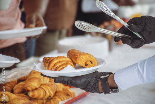 Plate of pastries served with tongs – Croissant and pain au chocolat close-up