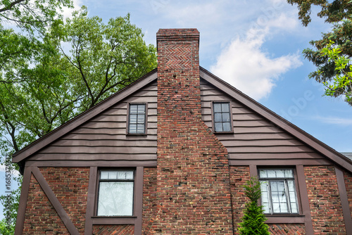 Traditional house exterior with large brick chimney and rustic wooden siding in Brookline, Massachusetts, USA
