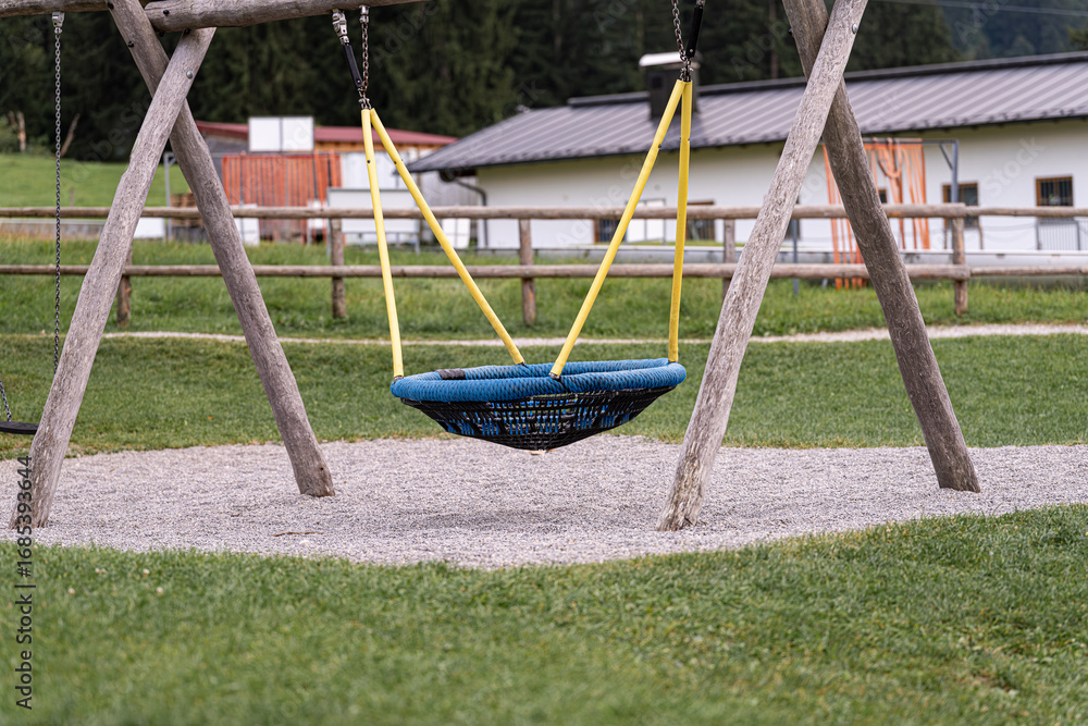 Obraz premium Swinging in a serene park setting with a cozy nest swing enjoying a sunny day