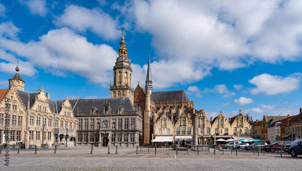 Fototapeta premium Veurne, Belgien – Historischer Marktplatz mit Kirche und Glockenturm bei Tageslicht