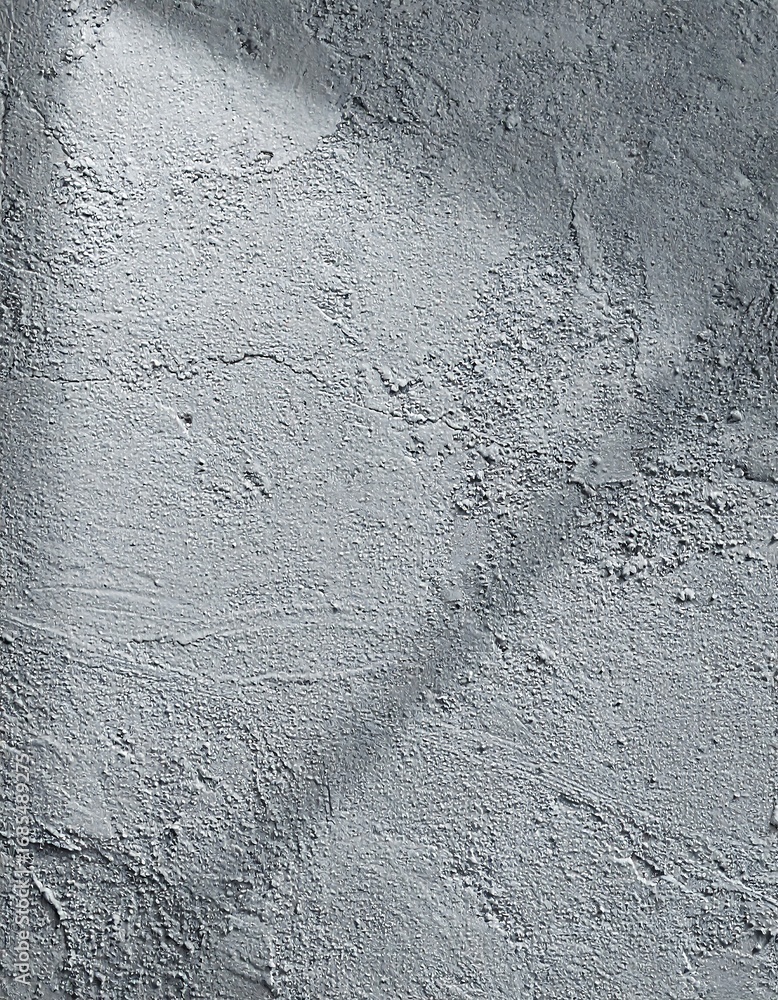 Obraz premium A textured gray surface, showcasing a variety of subtle surface imperfections and a prominent light source casting dramatic shadows.