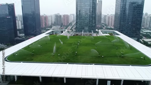 An elevated green space provides a tranquil oasis amidst towering buildings, offering a unique blend of nature and urban environment.