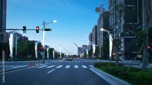 A long street with buildings on both sides stretches into the distance under a clear blue sky on a bright day.