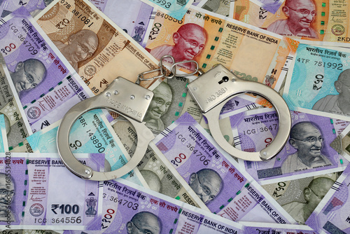 фотографія Handcuffs on Indian currency notes - Concept of Financial fraud