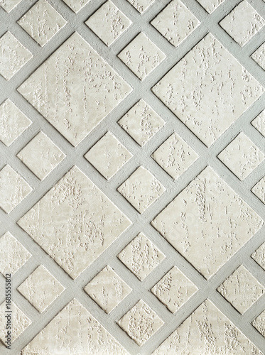 Textured wall surface featuring a geometric diamond pattern in light gray tones, showcasing intricate details and a modern aesthetic for interior design inspiration