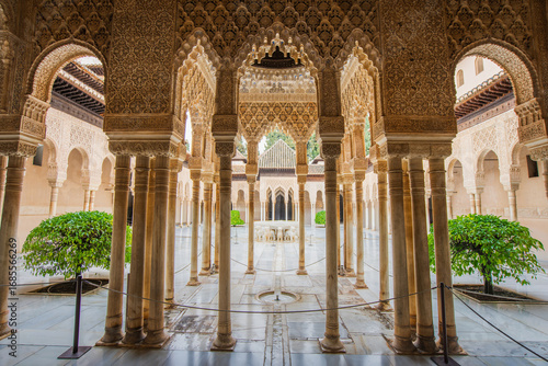 The Court of the Lions in Alhambra with its iconic fountain, marble columns, and ornate arches in the Nasrid Palace. Granada, Spain.