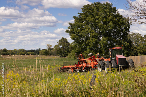 Billede på lærred Large farming tractor with disc harrow attached for soil cultivation and prepara