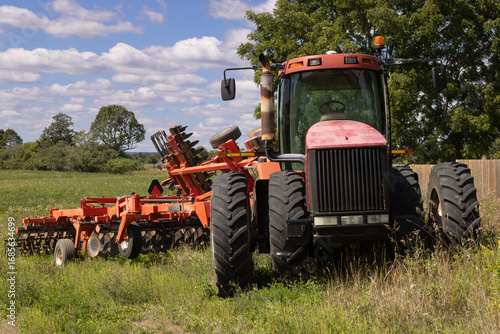 Obraz na plátně Front view of large powerful agricultural tractor connected to a tillage impleme