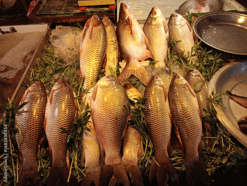 Fototapeta premium Fresh fish and seafood, prepared and raw, available at a bustling market