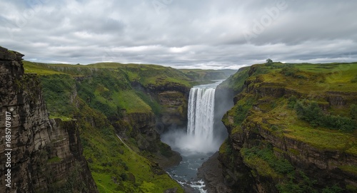 A Majestic Cascade. Waters Plunge Through Verdant Cliffs, A Scenic Landscape.