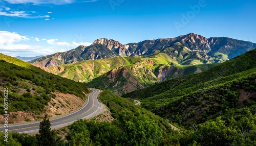 Winding road through a lush mountain valley under a clear sky