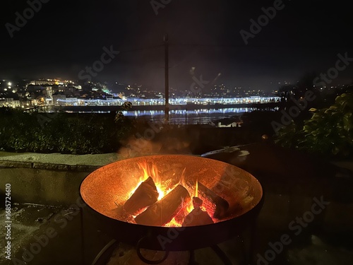 Fire pit on a winter night with city skyline in the background