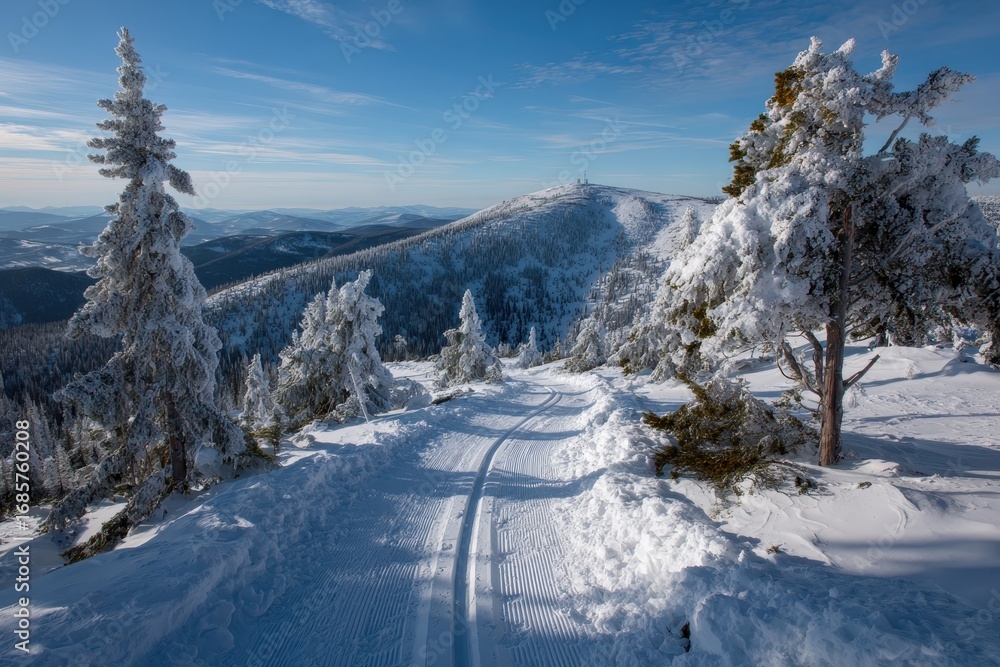 Obraz premium Winter mountain landscape features cross country skiers traversing snowy trails in a pristine natural setting under a clear blue sky