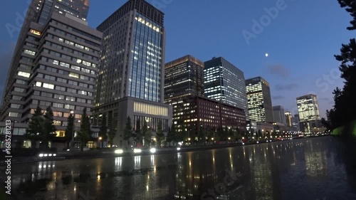 TOKYO, JAPAN - JULY 2025 : Urban cityscape of office buildings in sunset. A densely populated area with skyscrapers. Time lapse shot, dusk to night. Business, finance and technology concept 4K video.