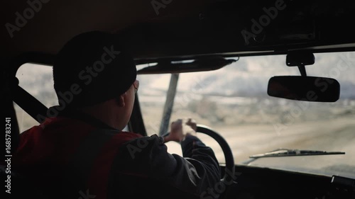 A driver in a reflective vest drives a car