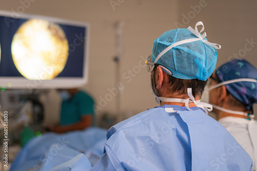 Surgeons observing endoscopy screen during medical procedure in hospital operating room
