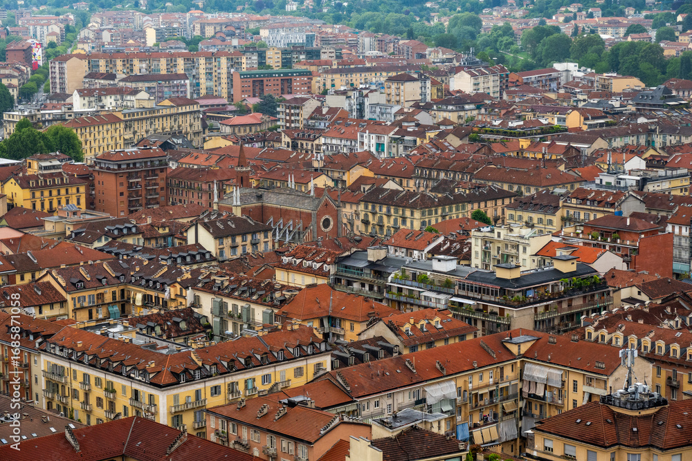 Fototapeta premium Aerial scene of Torino showcasing red-tiled rooftops of historic buildings and a scenic neighborhood.