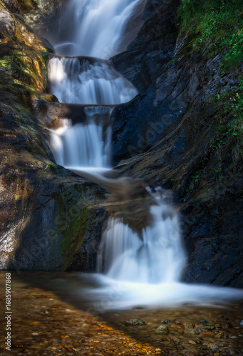 Spectacular tiered long-exposure waterfall in the wild gorge of Feichten, Austria. A serene and powerful natural landscape in the Kaunertal valley, Tyrol.