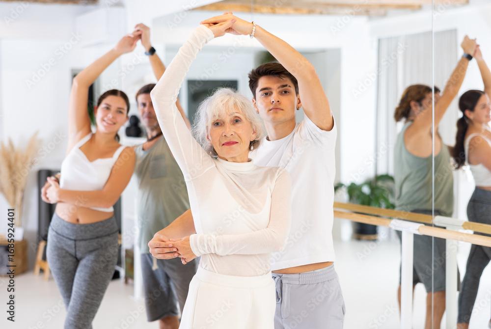 Fototapeta premium Elderly woman and young boy dancing pair dance in gym