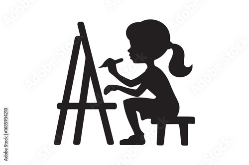 Silhouette of a young artist painting on an easel