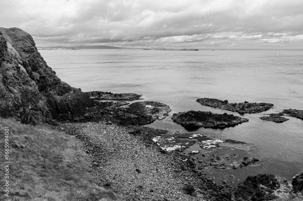 Obraz premium A rocky shoreline with a body of water in the background