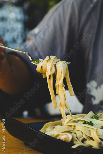Italian fettuccine pasta with cream, chicken and mushrooms. Creamy chicken and mushroom fettuccine pasta. Freshly cooked chicken mushroom fettuccine with cream.
