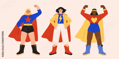 Three diverse women dressed as superheroes striking confident poses against a plain background