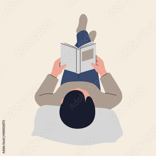 A person reading a book while lying on a pillow.