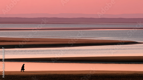 African woman walking alone on sandbar at dawn with soft pink and orange sky and flowing dress creating serene peaceful mood