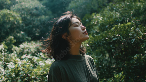 森の中で目を閉じて風を感じながら深呼吸する女性、リフレッシュ, 穏やか, 瞑想, 自然, 癒し、リラックス