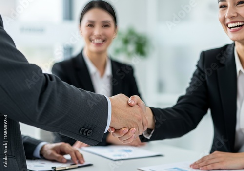 Wallpaper Mural Close-up Handshake Between Man in Grey Suit and Businesswoman with Blurred Colleagues Torontodigital.ca