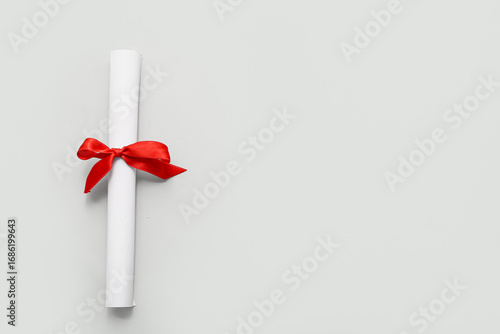 Diploma with red ribbon on ...