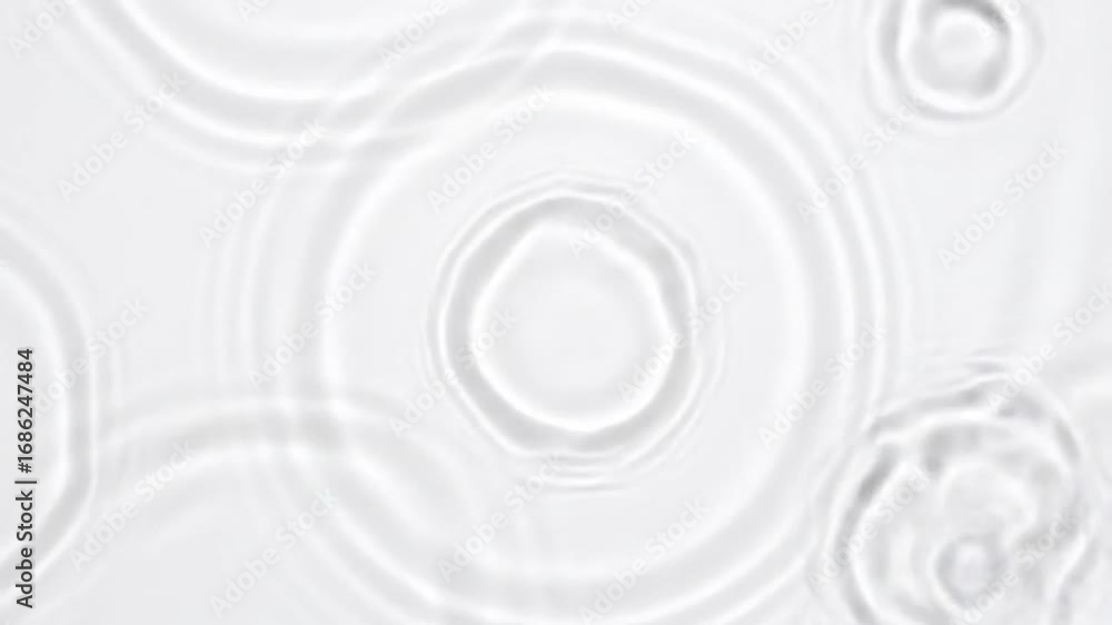 Circular ripples expand softly on a white, textured surface Circular ripples expand softly on a white, textured surface