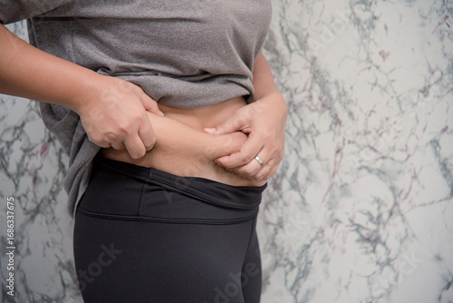woman touching his belly on white background , fat